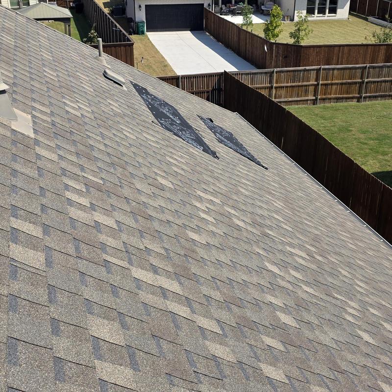 Asphalt roof shingles with visible hail damage patches Asphalt roof shingles with visible hail damage patches