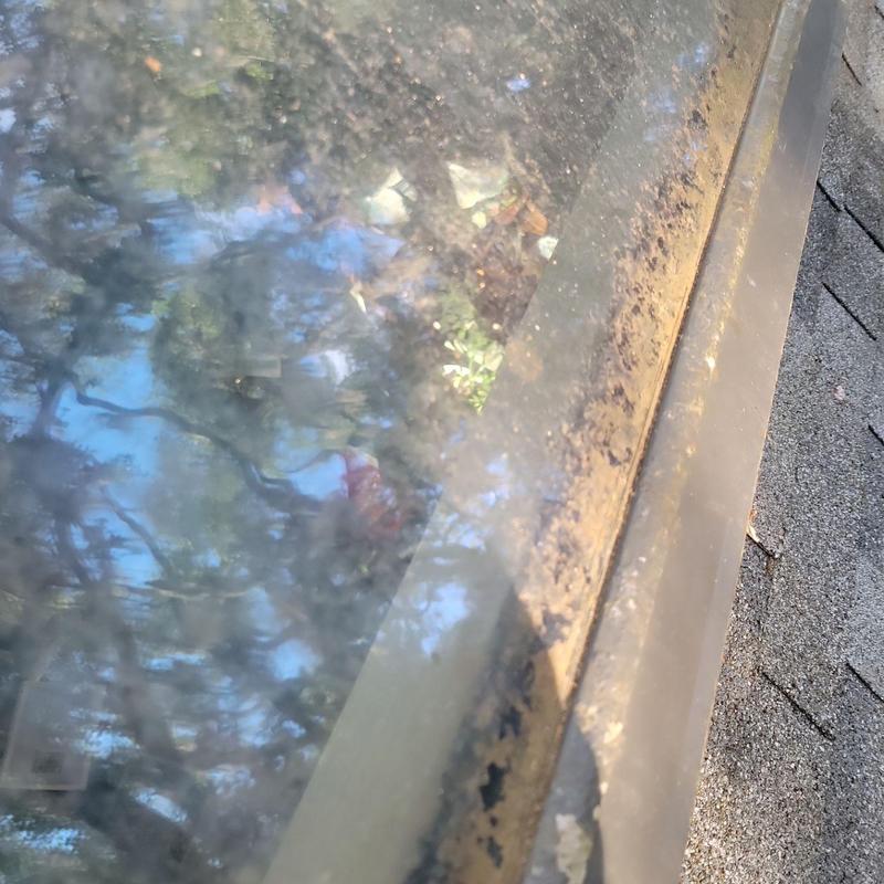 Skylight glass and frame with dirt buildup on roof Skylight glass and frame with dirt buildup on roof
