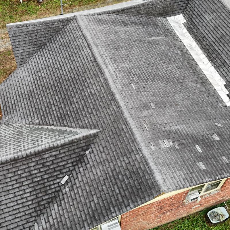 Asphalt shingle roof with visible wear and patching