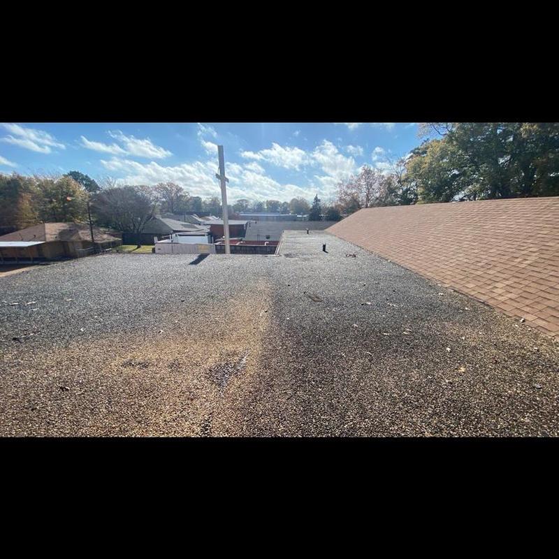 Gravel-covered flat roof surface during inspection Gravel-covered flat roof surface during inspection