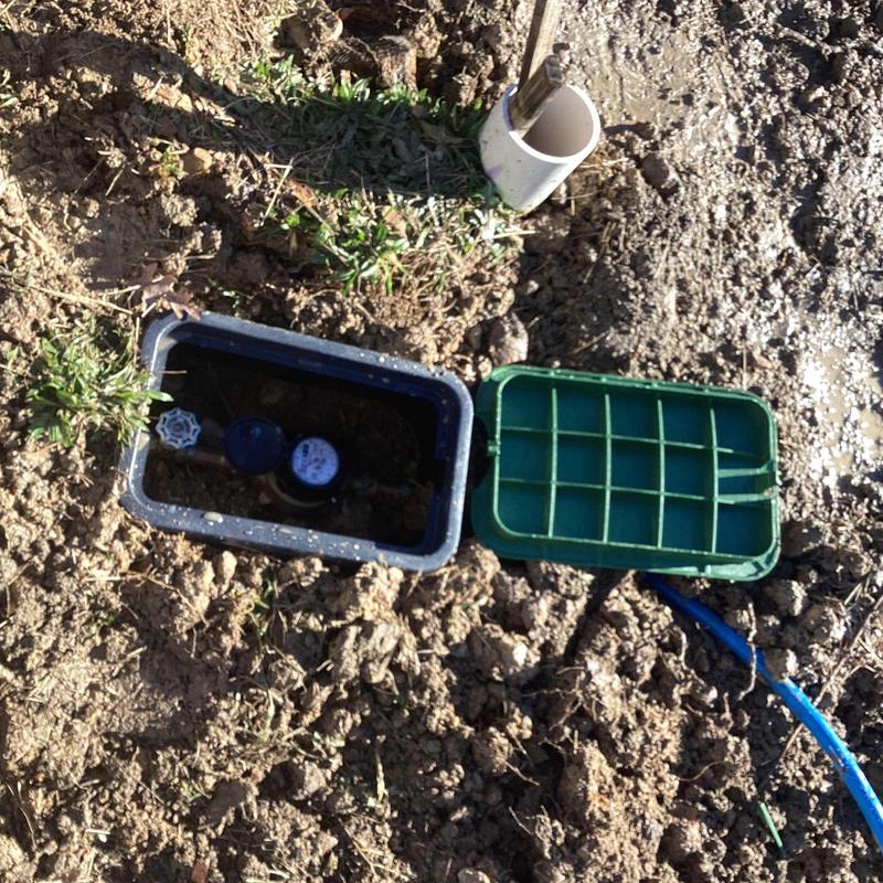 Water meter box installation with capped main line and stubbed pipe