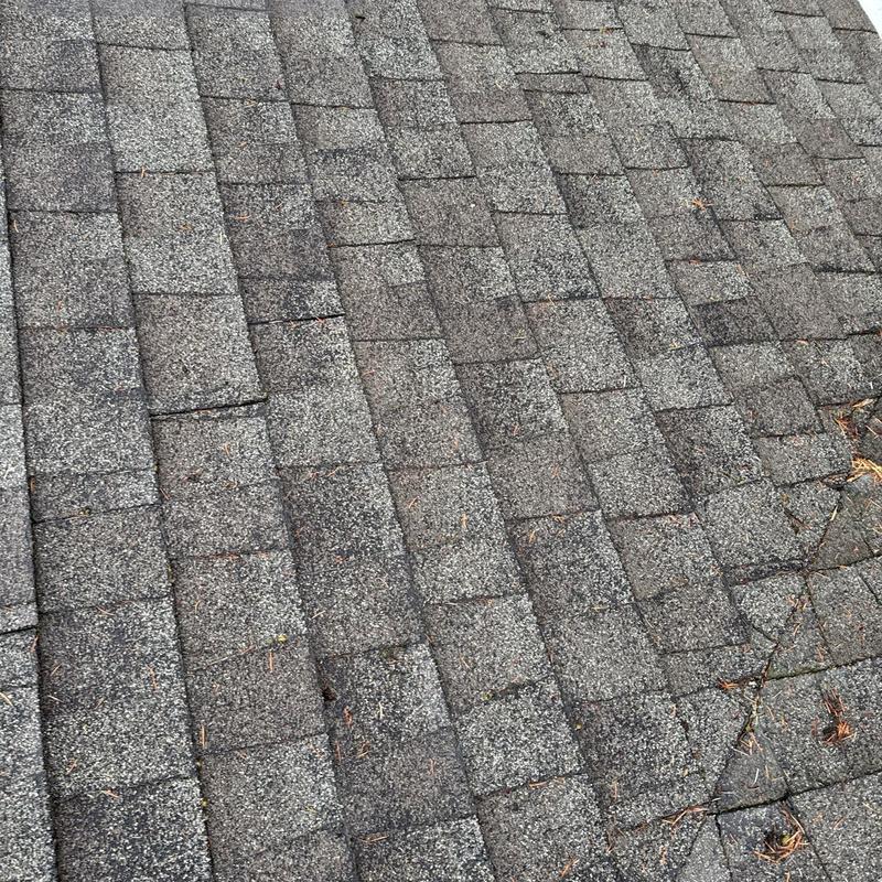 Asphalt roof shingles with visible wear and damage