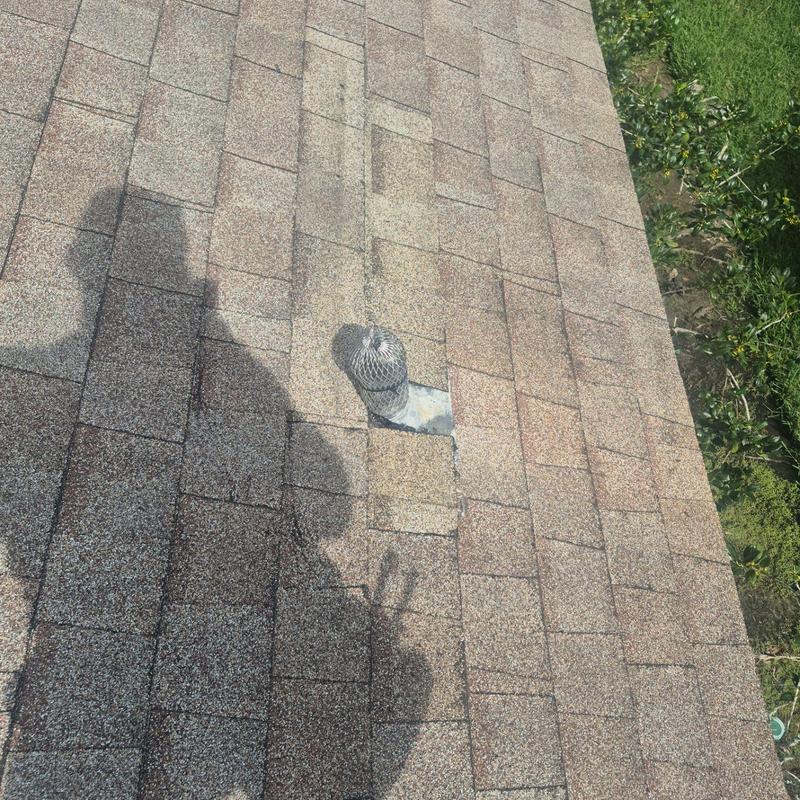 Pipe boot with sealed shingles on asphalt roof ridge Pipe boot with sealed shingles on asphalt roof ridge