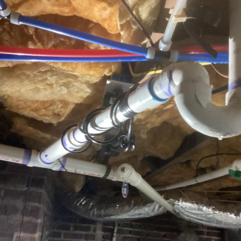 Ice maker drain line with plumbing in basement ceiling
