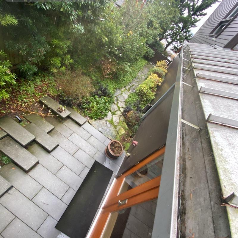 Gutter cleaning and debris removal on metal roof edge