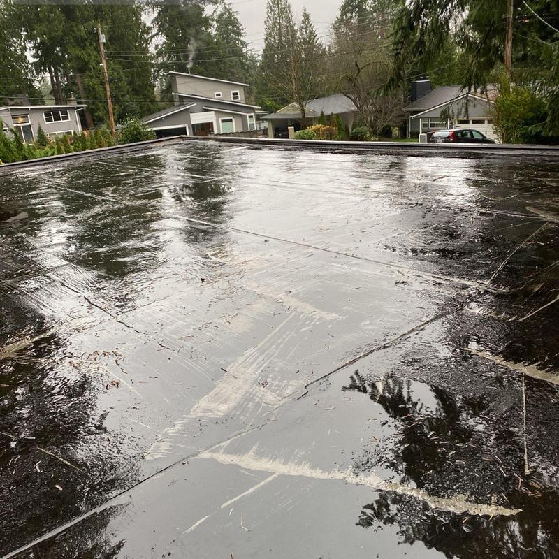 Flat roof surface with water pooling and debris