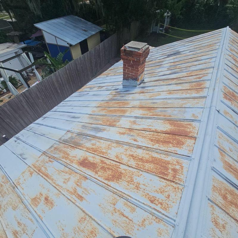 Rusty metal roof with brick chimney and fence background Rusty metal roof with brick chimney and fence background