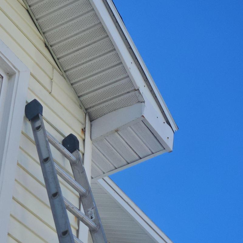 Soffit panels on house exterior with ladder nearby Soffit panels on house exterior with ladder nearby
