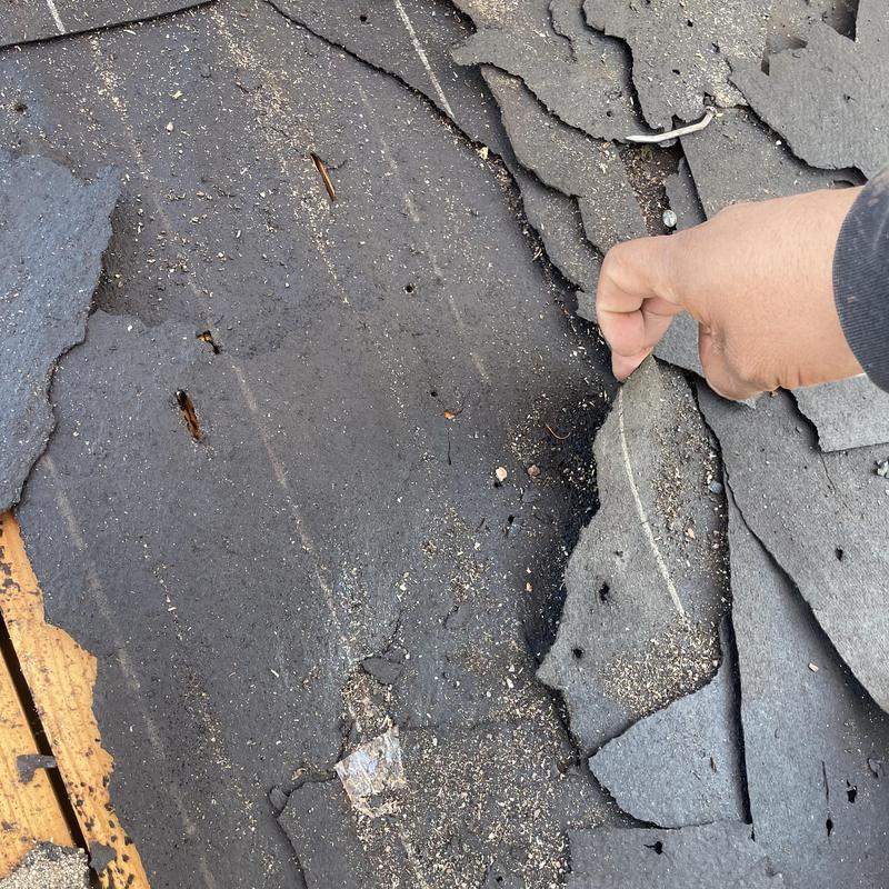 Asphalt roof shingles being peeled during roof install