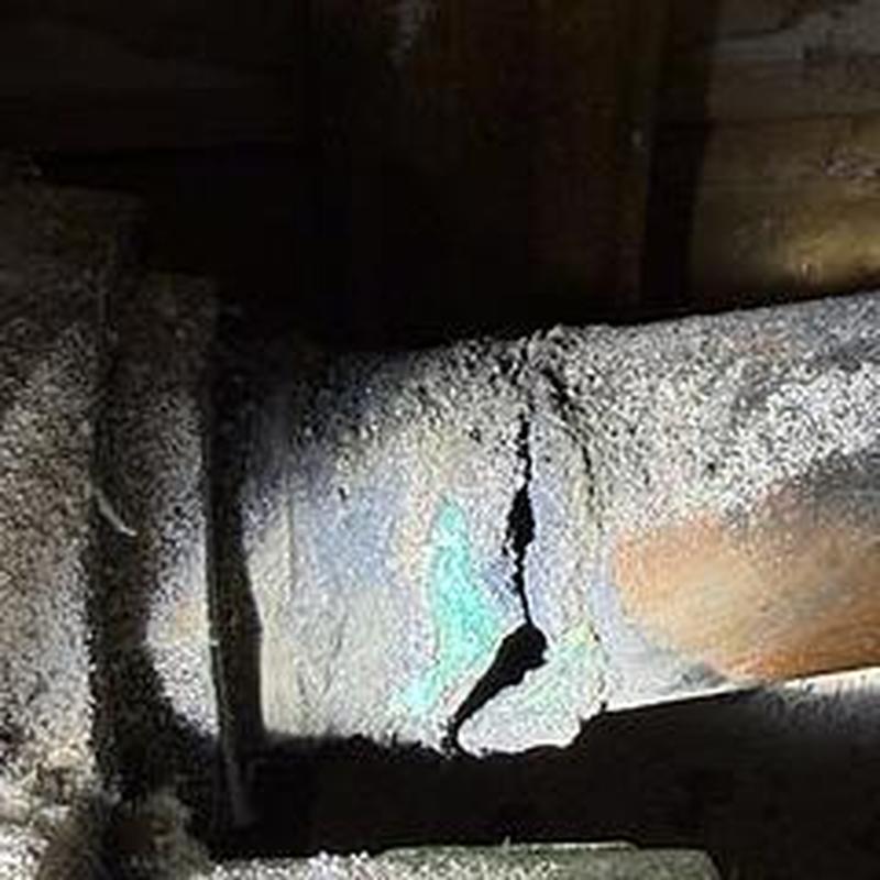 Corroded 4-inch cast iron sewer pipe with crack