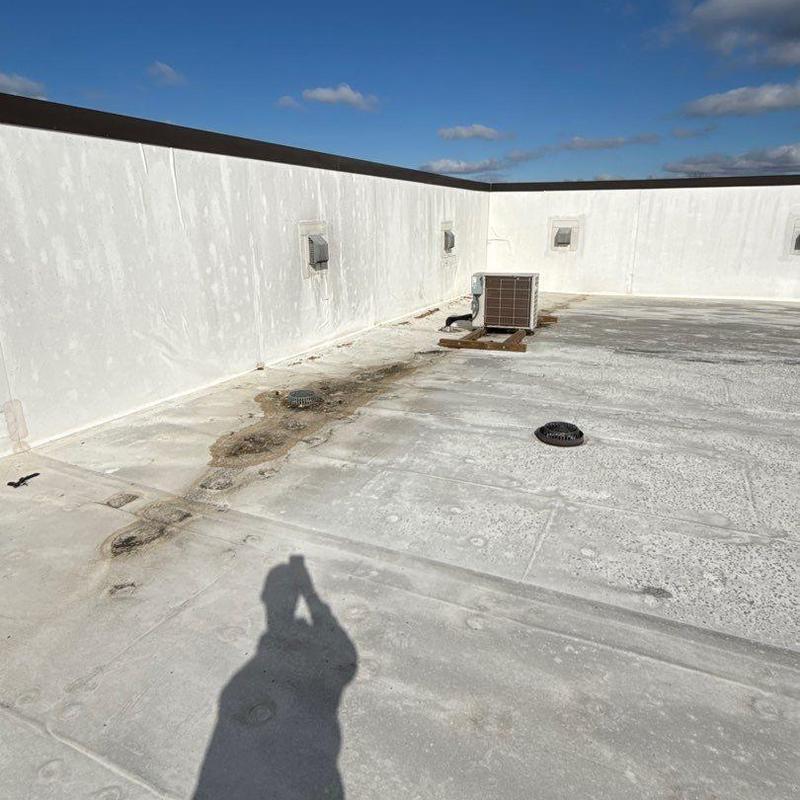 Flat roof membrane with drainage issues and HVAC unit