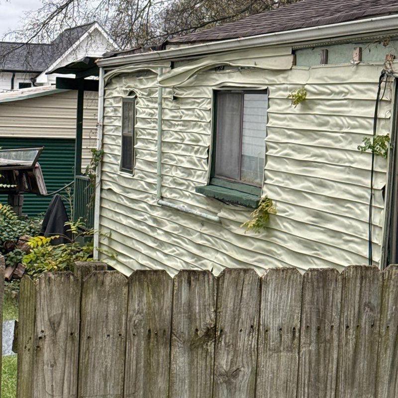 Vinyl siding warped by heat damage on house exterior