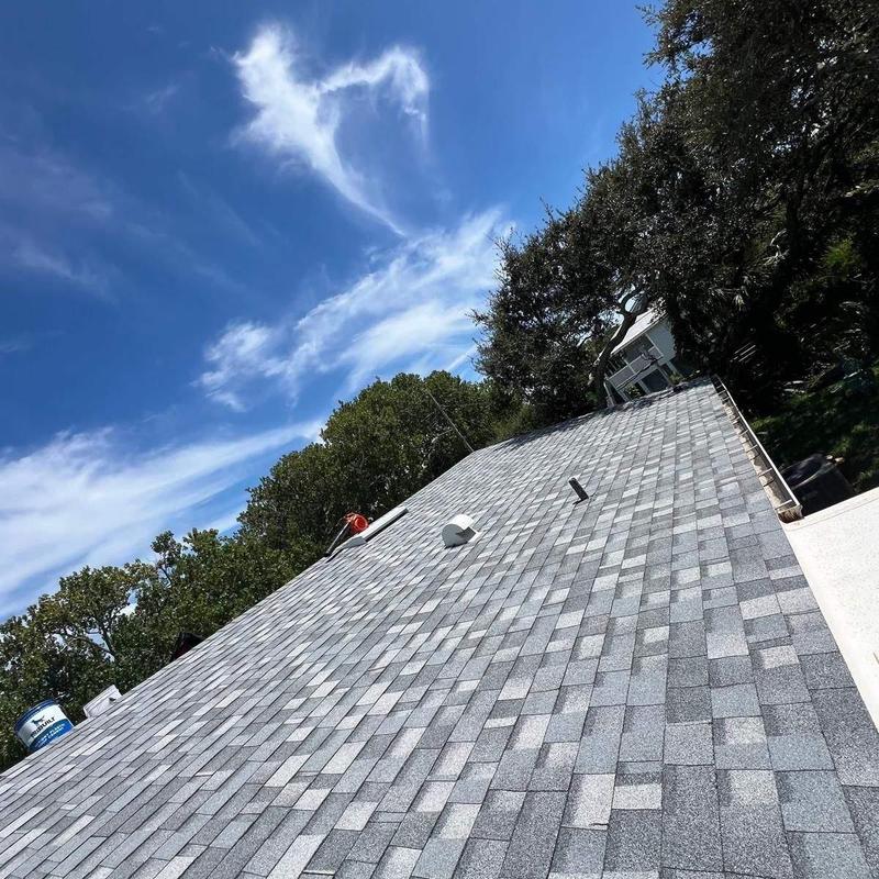 Asphalt shingle roof installation under clear sky Asphalt shingle roof installation under clear sky