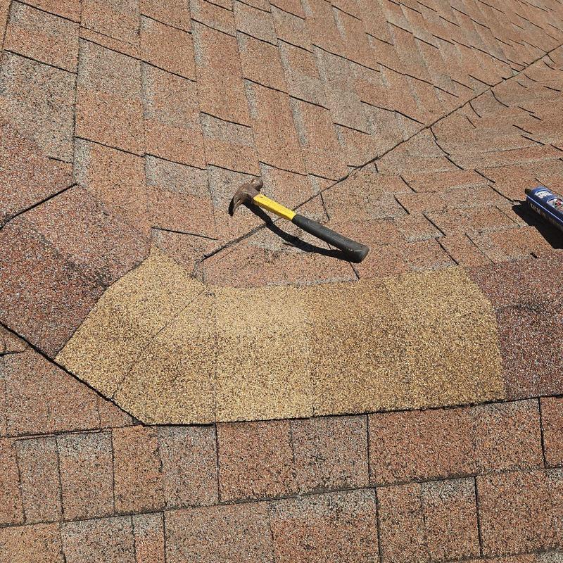 Hip shingles replacement section with hammer on roof Hip shingles replacement section with hammer on roof