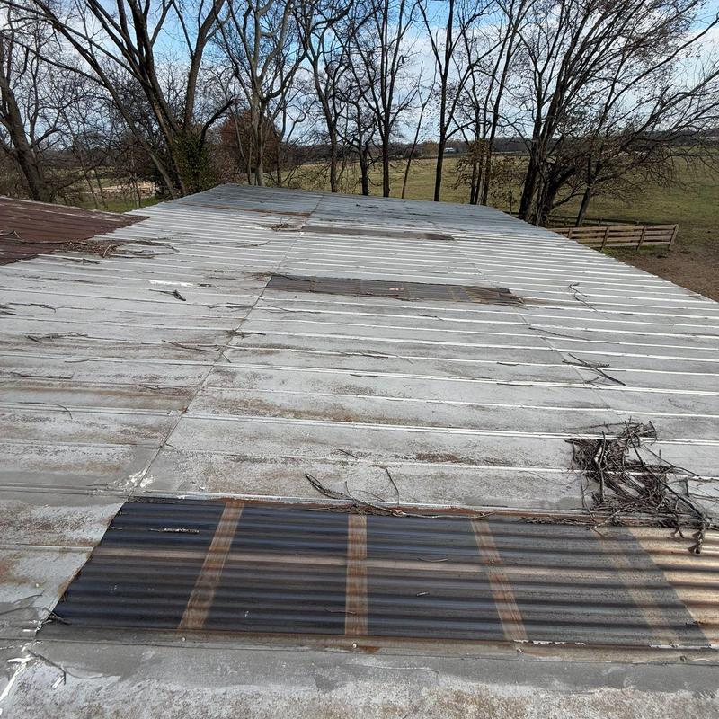 Metal roof panels showing wear and debris buildup