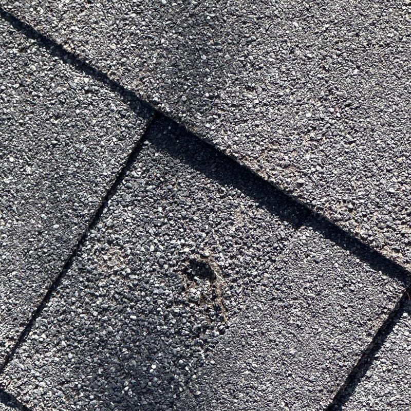 Owens Corning shingle with hail damage and dent