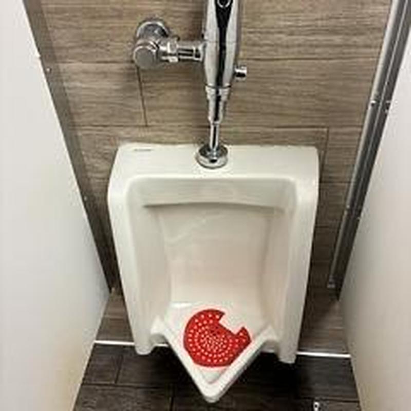 Urinal drain with red drain screen and flush valve