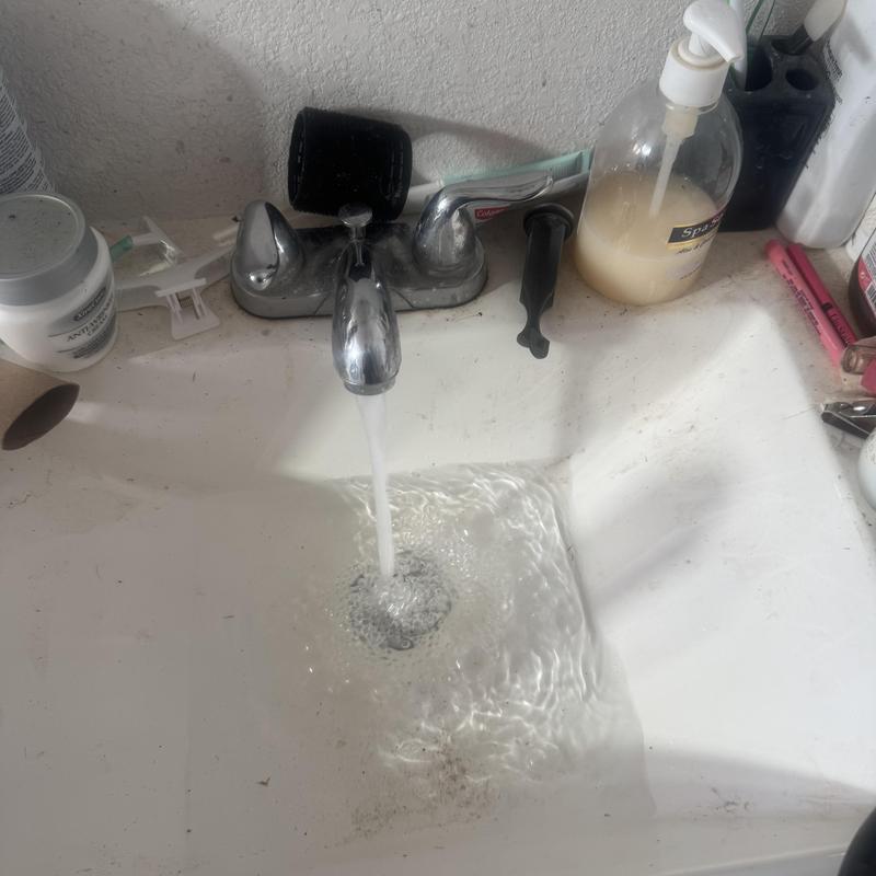 Bathroom sink drain with running water and soap dispenser