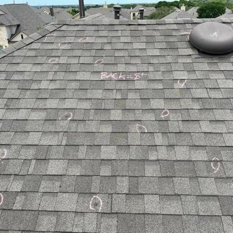 Asphalt shingle roof with hail damage marked in chalk