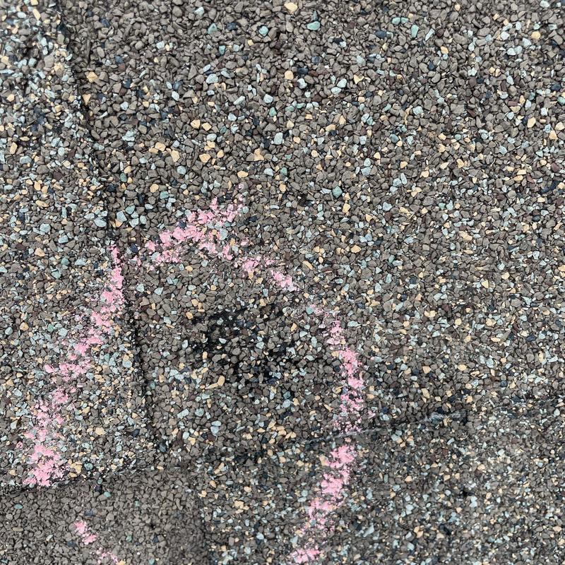 Asphalt shingle hail damage marked for inspection