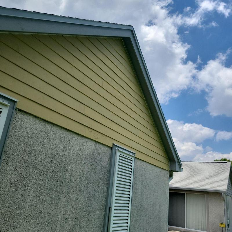Fiber cement lap siding on house exterior under roofline Fiber cement lap siding on house exterior under roofline