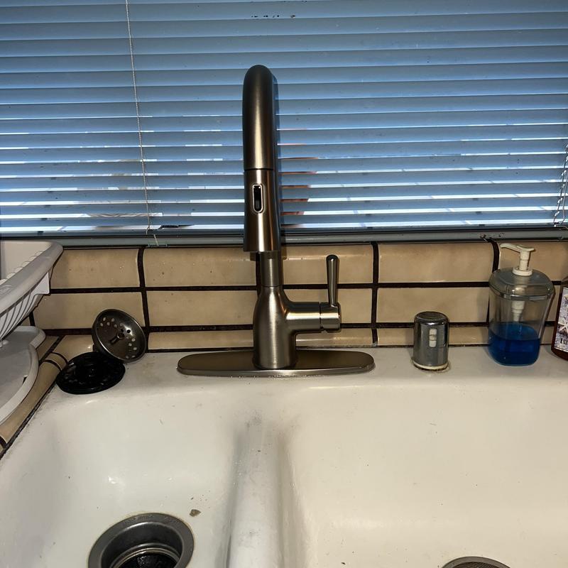 Kitchen pullout faucet installed over sink with soap dispenser