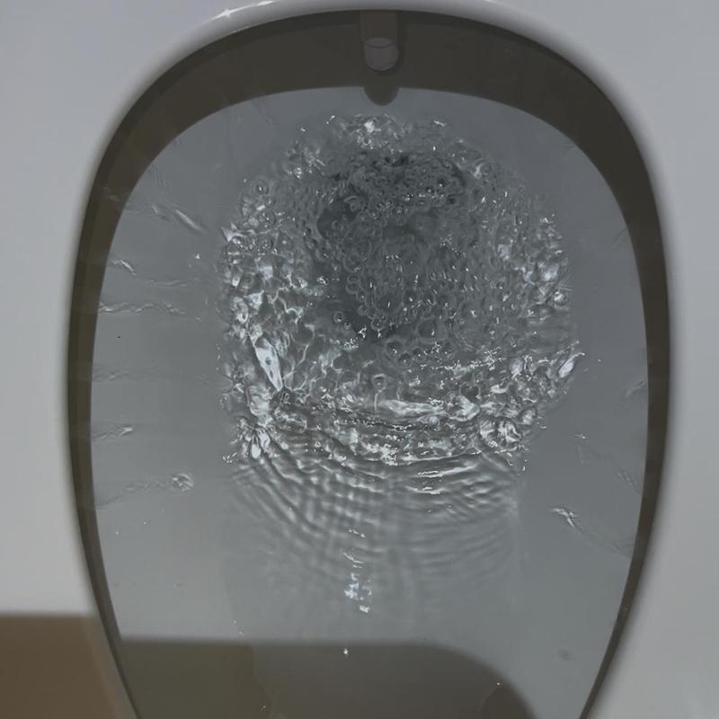 Toilet bowl flushing with clear water flow