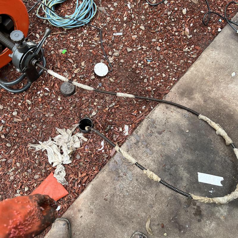 Main drain snake cable clearing clog outdoors