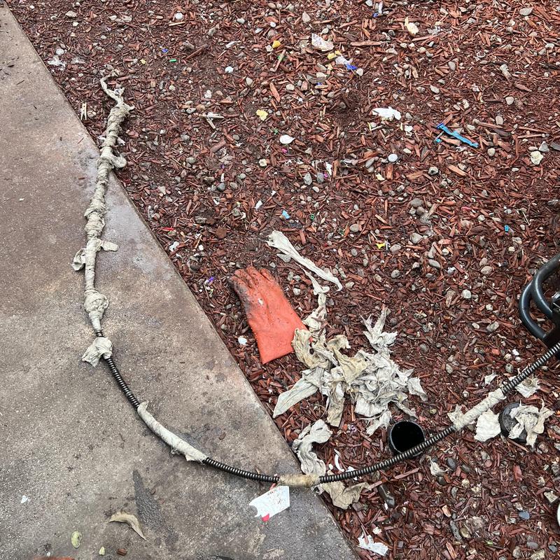Main drain clog removal with snake and debris on ground