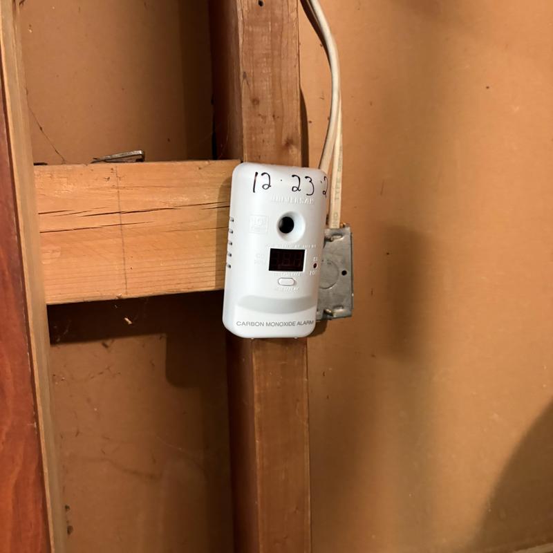 Carbon monoxide alarm mounted on wall stud