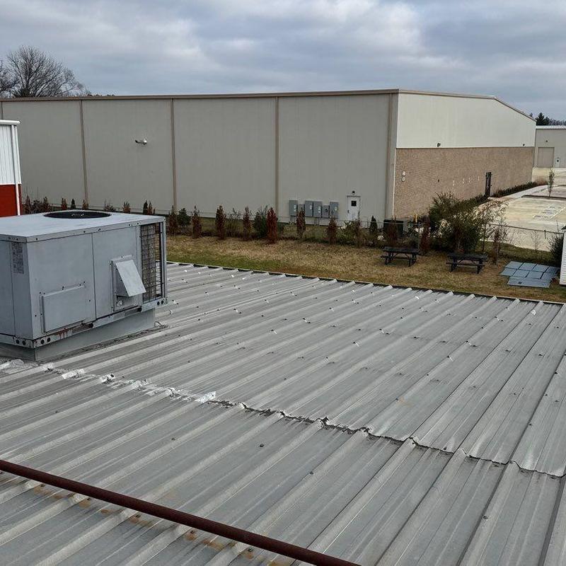 Metal roof panels with hail damage near rooftop unit