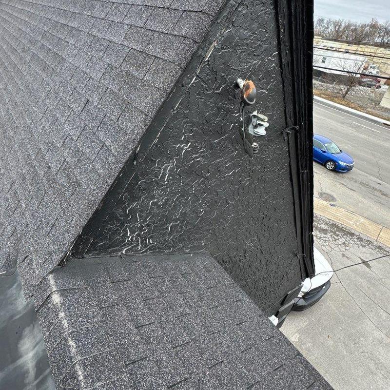 Asphalt shingles and stucco wall near roof edge