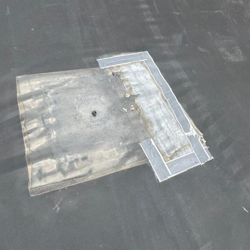 Flat roof membrane with patch repair and sealing tape