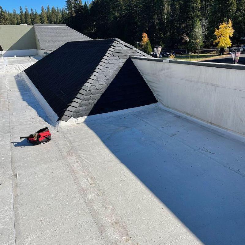 Silicone-coated commercial flat roof with pyramid skylight