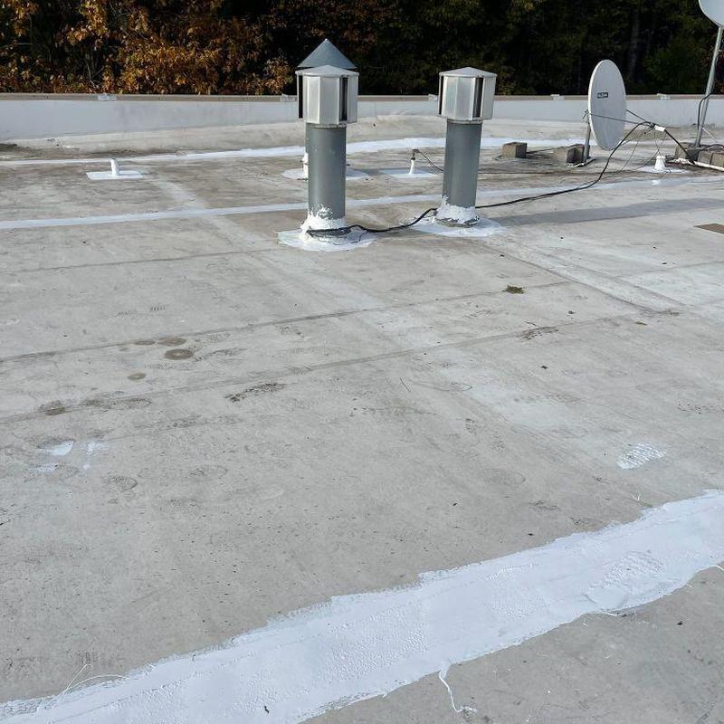 Silicone roof coating on commercial flat roof vents