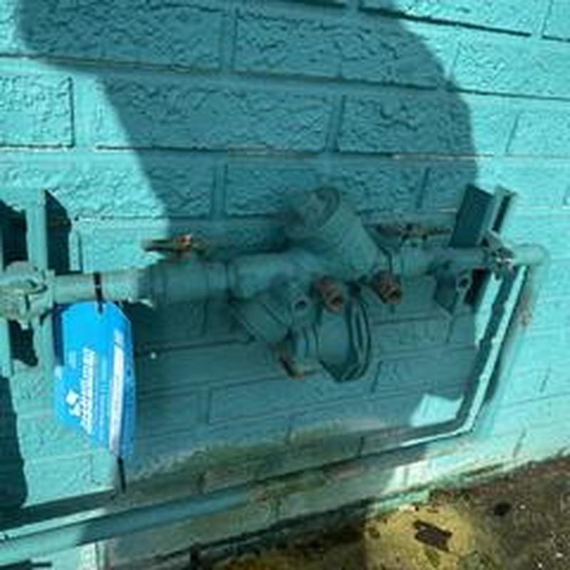 Backflow prevention device installed on brick wall