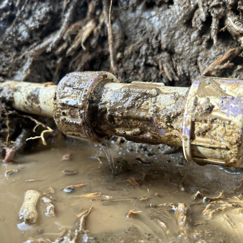 PVC water pipe leaking underground in muddy soil