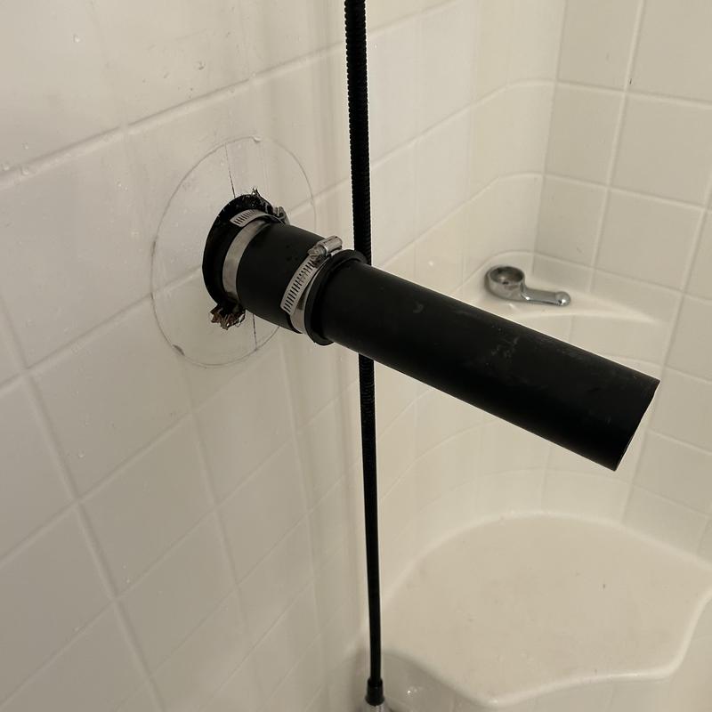 Shower valve pipe with hose clamps in tiled stall