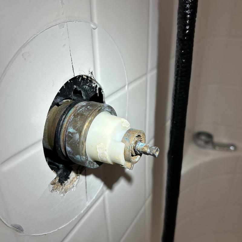 Shower valve cartridge removed from tiled wall installation