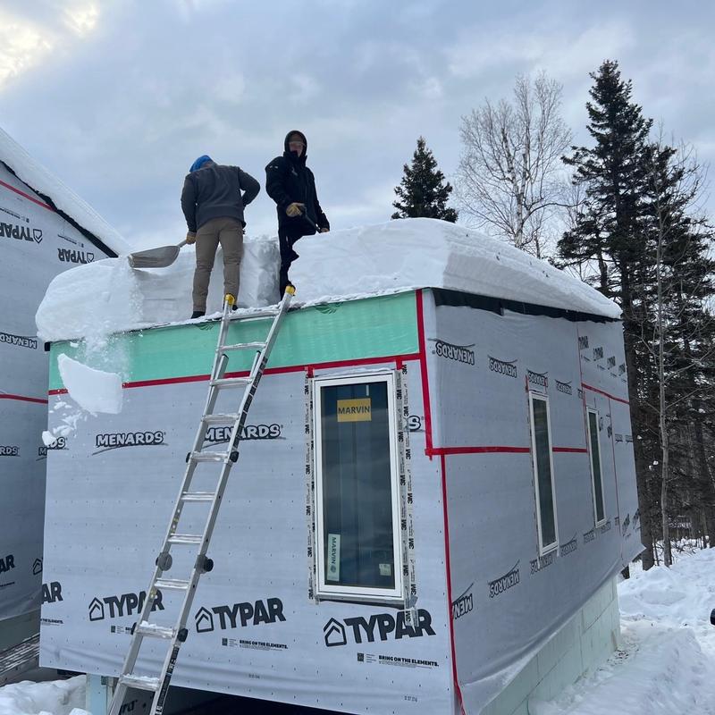 Roof snow removal on building under construction Roof snow removal on building under construction
