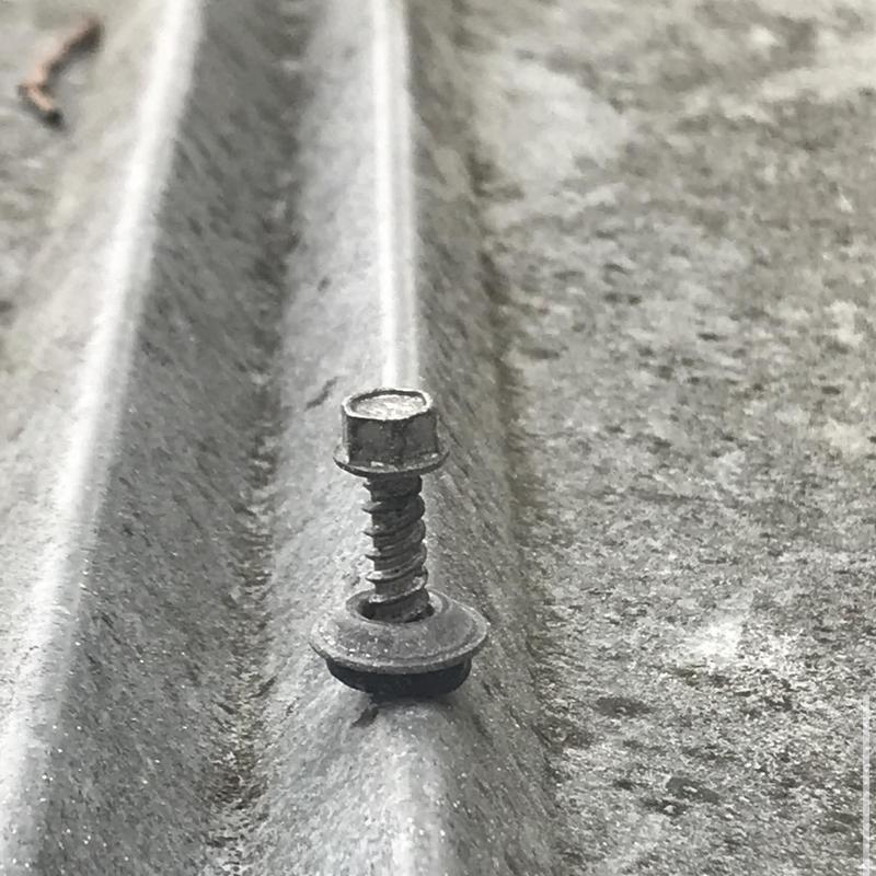 Metal roof screw backing out from panel expansion