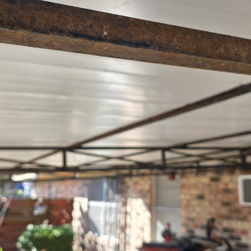Metal garage ceiling framework with rust and wear