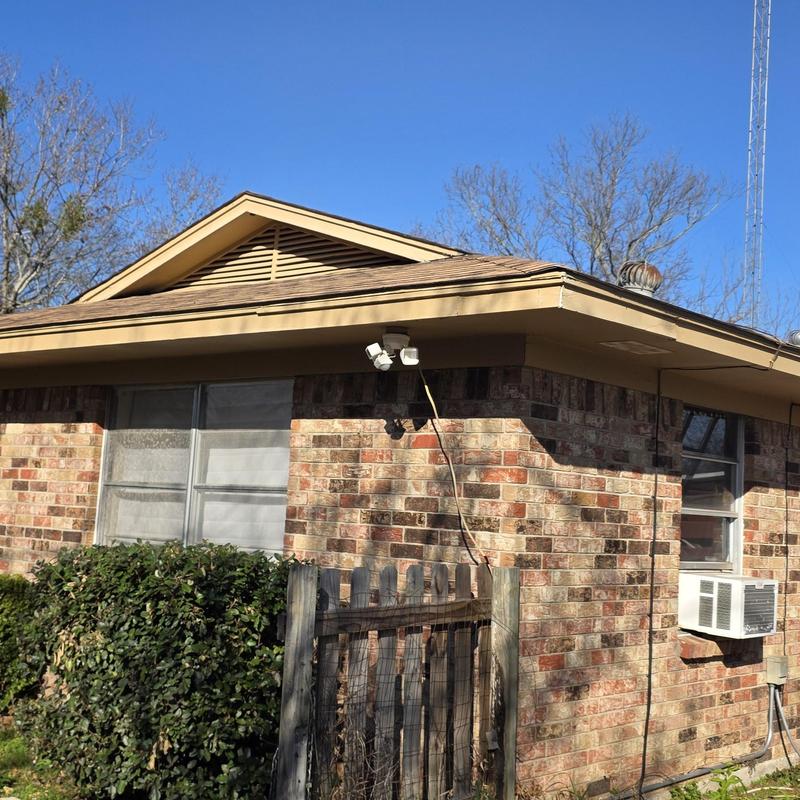 Roof shingles and flashing on brick house exterior