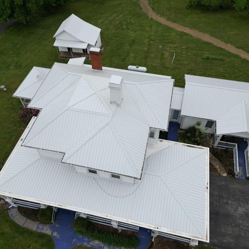 Metal roofing system with chimney and surrounding structures