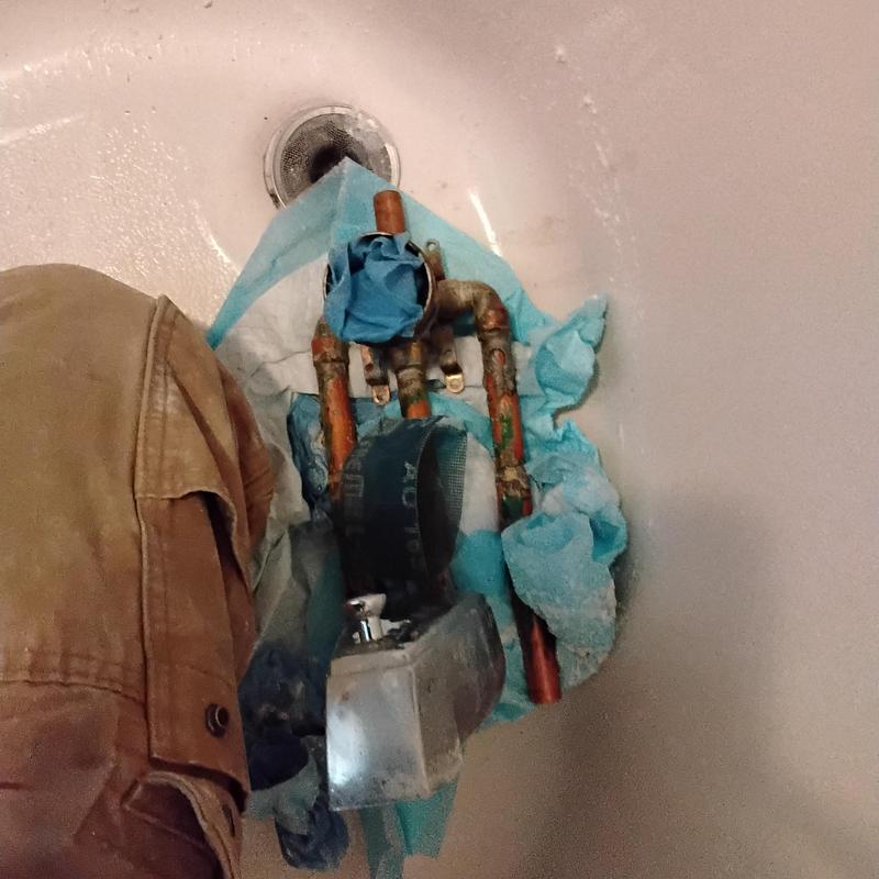 Bathtub faucet plumbing pipes exposed in tub wall