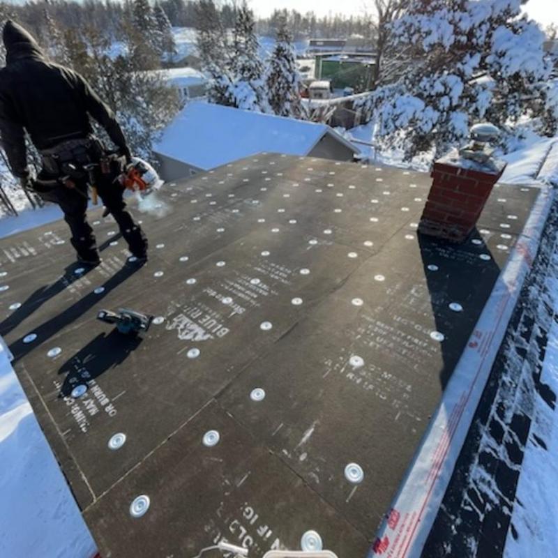 EPDM rubber roof installation on snow-covered house EPDM rubber roof installation on snow-covered house
