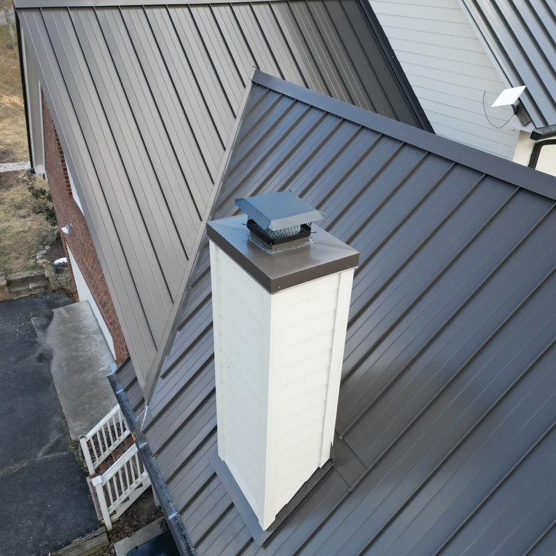 Metal roof panels around chimney with flashing installation