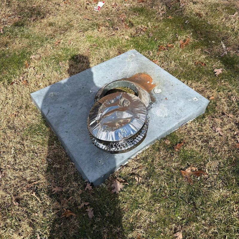 Metal vent cover on concrete slab outdoors