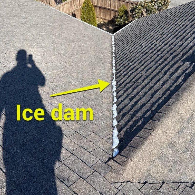 Ice dam on shingle roof valley with shadow and arrow