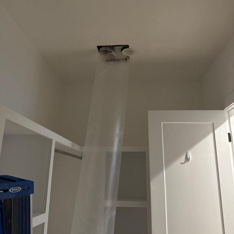 Ceiling vent undergoing plastic containment installation